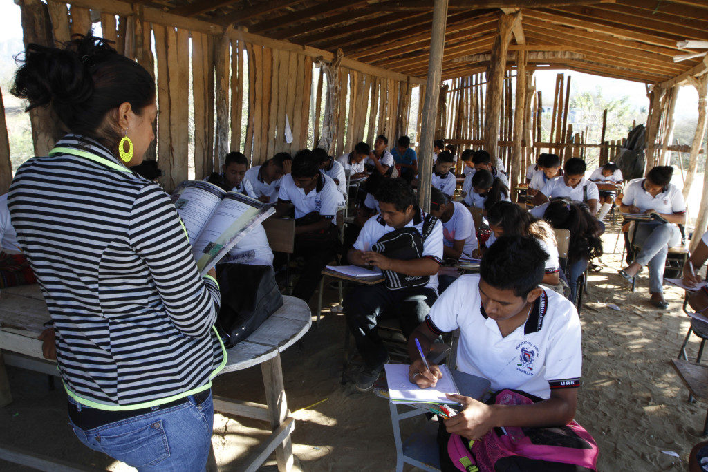 ACAPULCO, GUERRERO, 11MARZO2014.- Alumnos de la preparatoria popular de la comunidad de Sabanillas, toman clases en un salon inprovisado de palos de madera y piso de tierra debido a que autoridades educativas han abandonado dicho instituto de educación por la carencia de recursos federales, estatales y municipales.Padres de familia a base de coperaciones economicas que sostienen las necesidades basicas. FOTO: BERNANDINO HERNANDEZ /CUARTOSCURO.COM